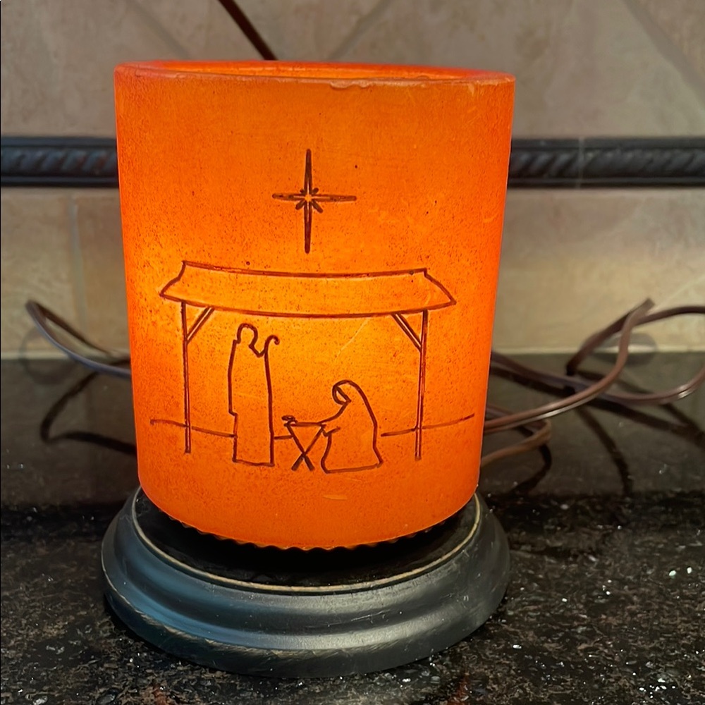 Nativity Scene Candle Sleeve in a Soft Golden Brown Glow over a separate light